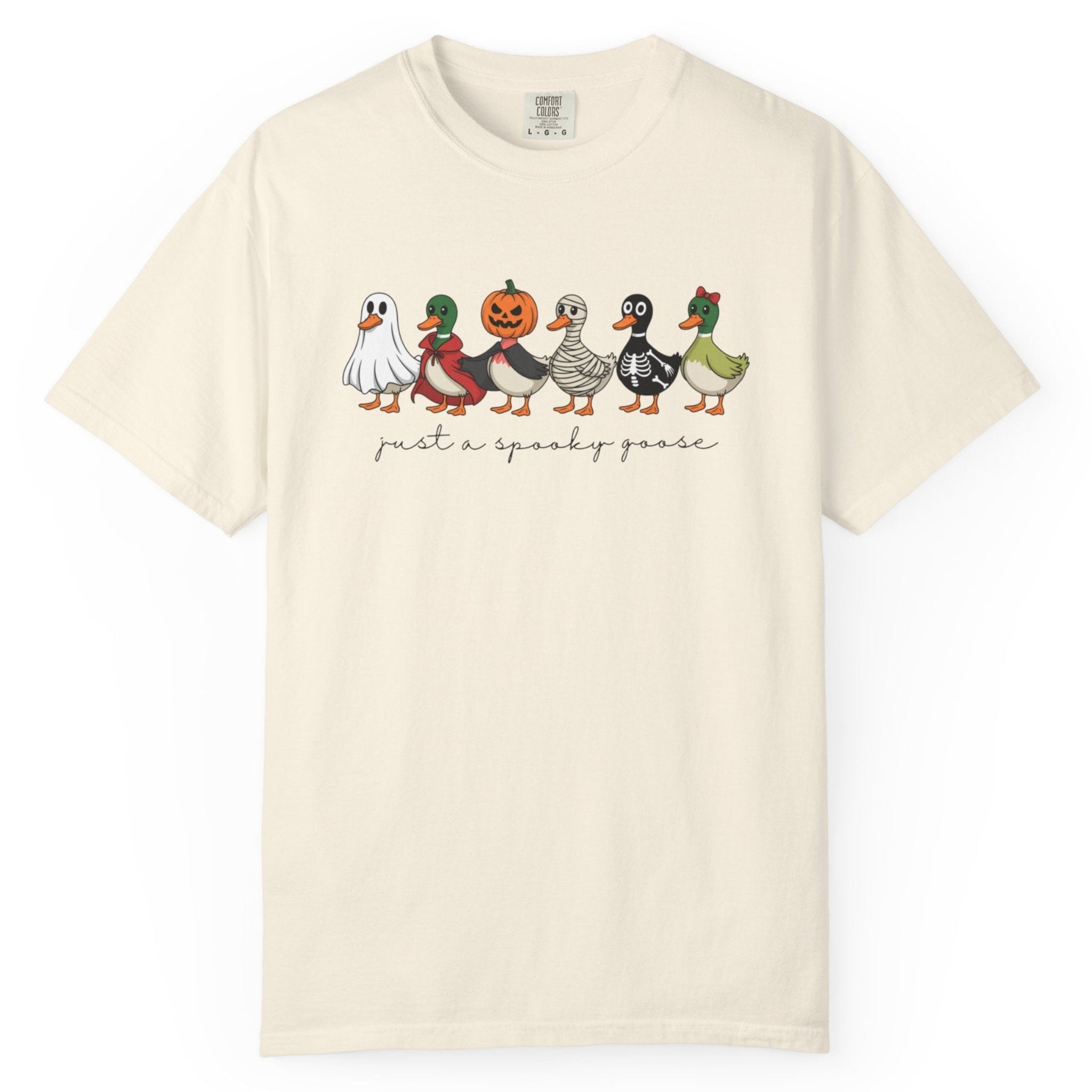 An ivory short-sleeve crewneck t-shirt featuring a graphic of five walking ducks dressed in Halloween costumes, with the text 'just a spooky goose'  printed below 