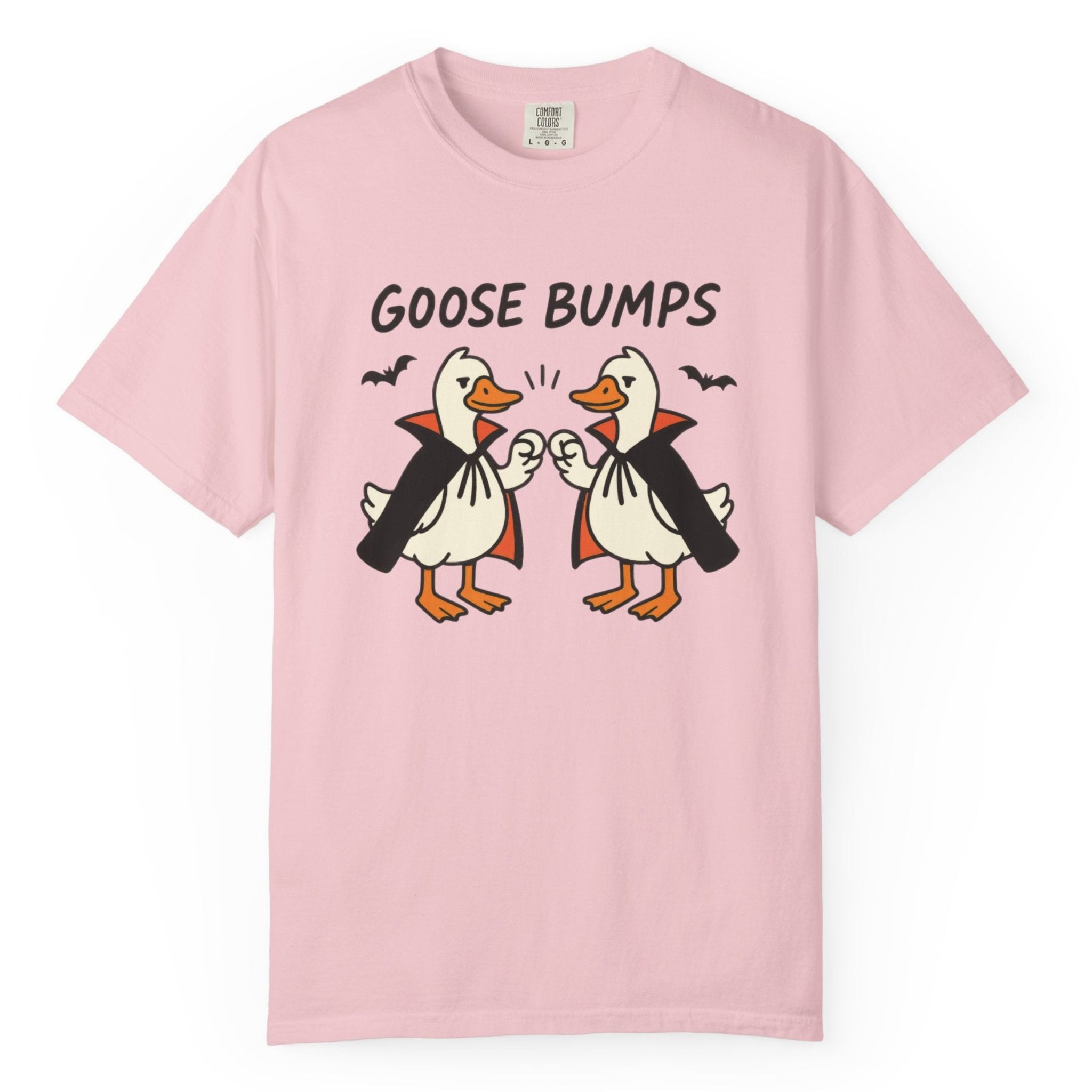 A light pink short-sleeve t-shirt with a graphic of two geese in black and orange, with the text 'GOOSE BUMPS' above them