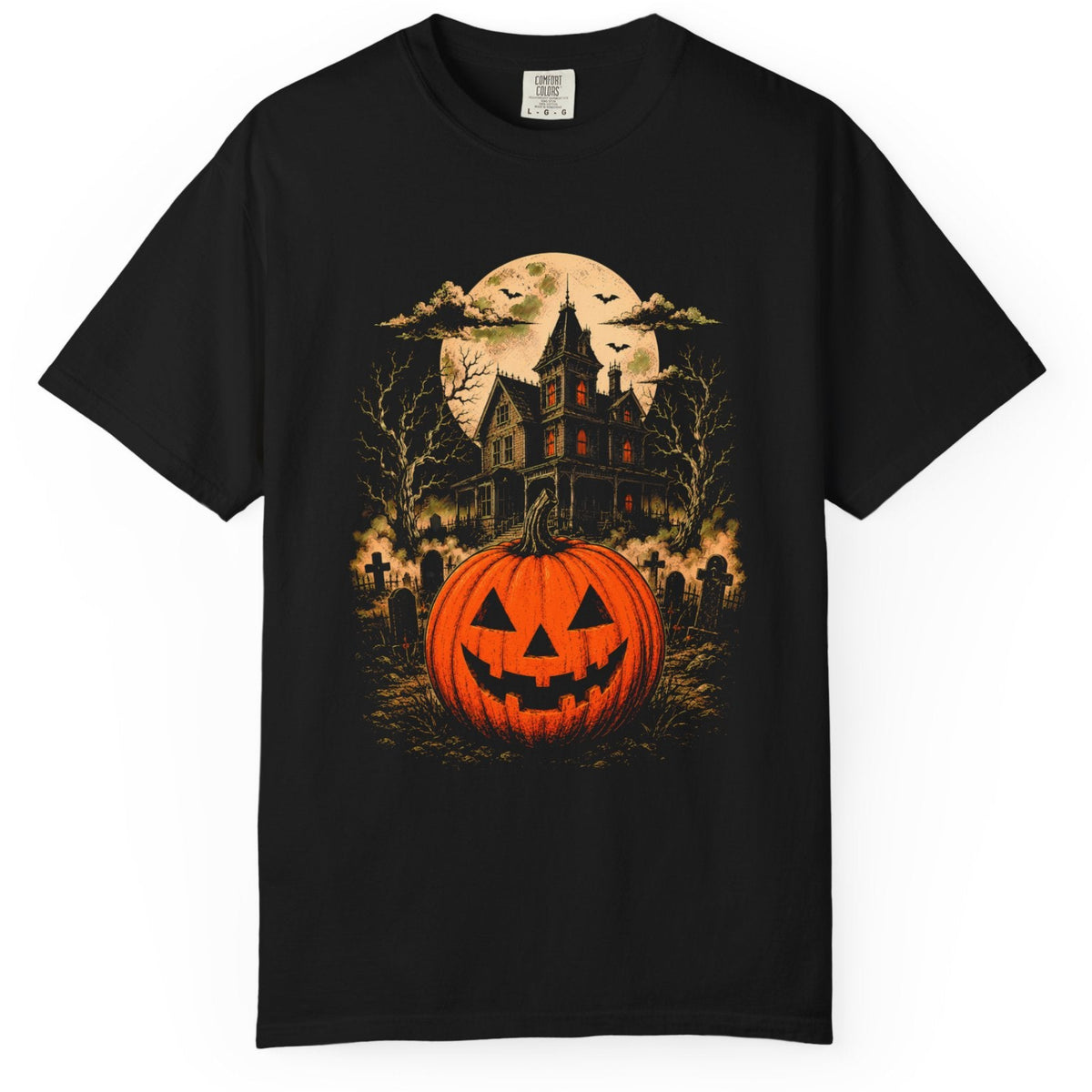 A black short-sleeve crewneck t-shirt featuring a detailed Halloween graphic print on the front. The graphic depicts a glowing orange jack-o'-lantern pumpkin in the foreground, with a spooky haunted house, bare trees, bats, and a full moon in the background.