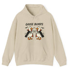 A sand/beige hoodie with a graphic of two geese in black and white costumes with orange beaks, under the text 'GOOSE BUMPS'. 