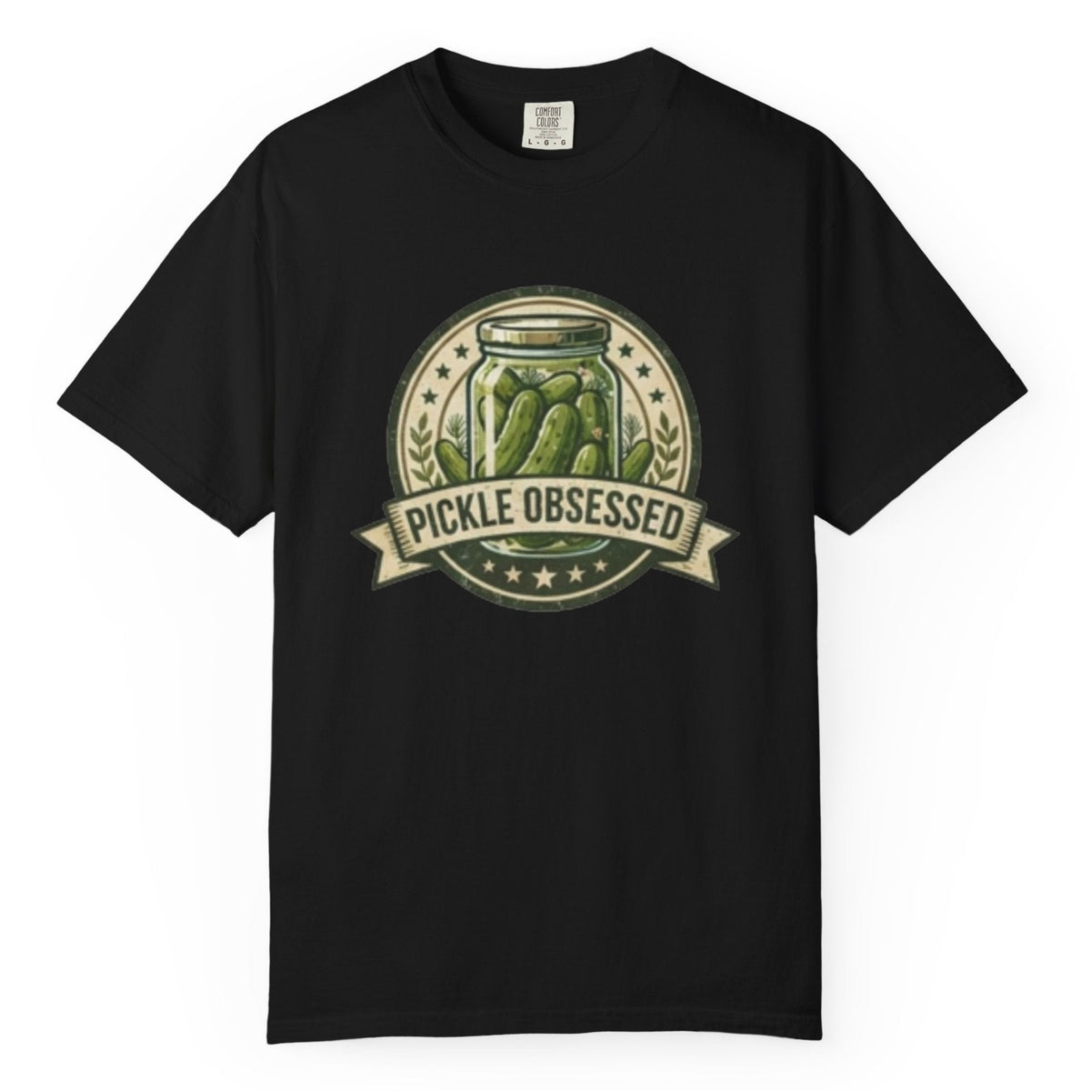 A black short-sleeve t-shirt hanging on a wooden hanger against a light wood pegboard wall. The shirt features a circular graphic print with a jar of pickled green onions and the words 'PICKLE OBSESSED' in a banner.