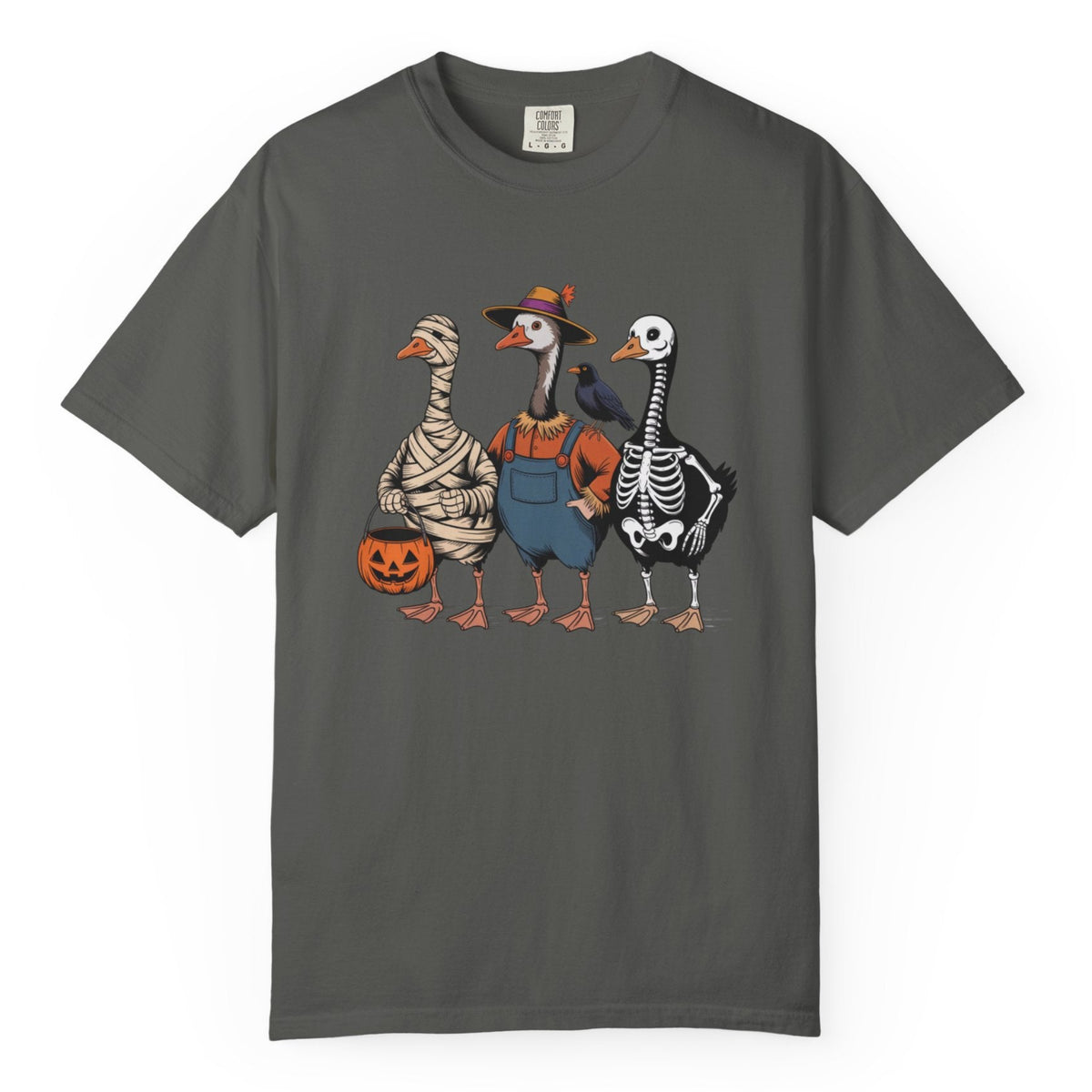 A pepper crewneck t-shirt featuring a graphic print of three cartoon geese dressed in Halloween costumes (mummy, farmer, and skeleton) holding pumpkin buckets, displayed on a clean white background.