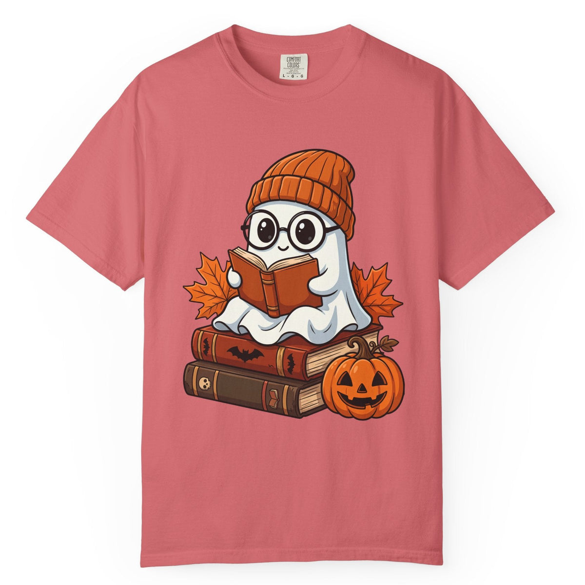 A dusty rose pink short-sleeve t-shirt with a cartoon graphic of a ghost reading books on Halloween, displayed on a clean white background.