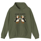 A military green hoodie with a graphic of two geese in black and white costumes with orange beaks, under the text 'GOOSE BUMPS'. 