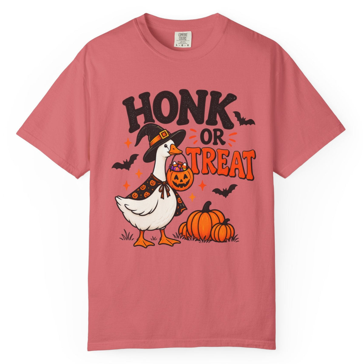 A dusty rose pink short-sleeve t-shirt with a Halloween graphic on the front. The graphic features the text 'HONK OR TREAT' in black and orange, a cartoon goose wearing a witch hat and holding a pumpkin, two pumpkins, and small black bats.