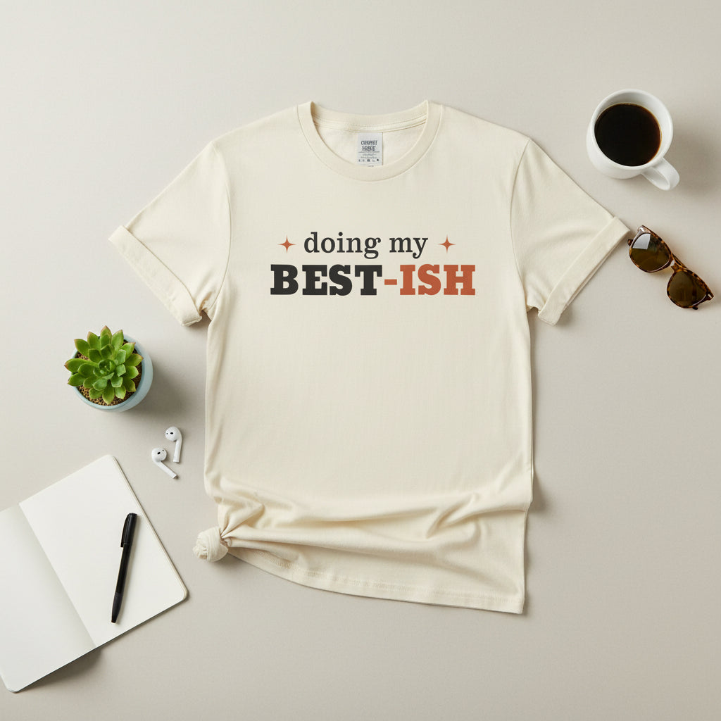 An off-white short-sleeve crewneck t-shirt with a graphic text print reading 'doing my BEST-ISH' on the chest, displayed against a solid white background.