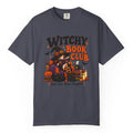 A navy blue crewneck t-shirt featuring a colorful graphic print on the front with the text 'WITCHY BOOK CLUB' and a Halloween-themed illustration of a witch, pumpkins, and candles.
