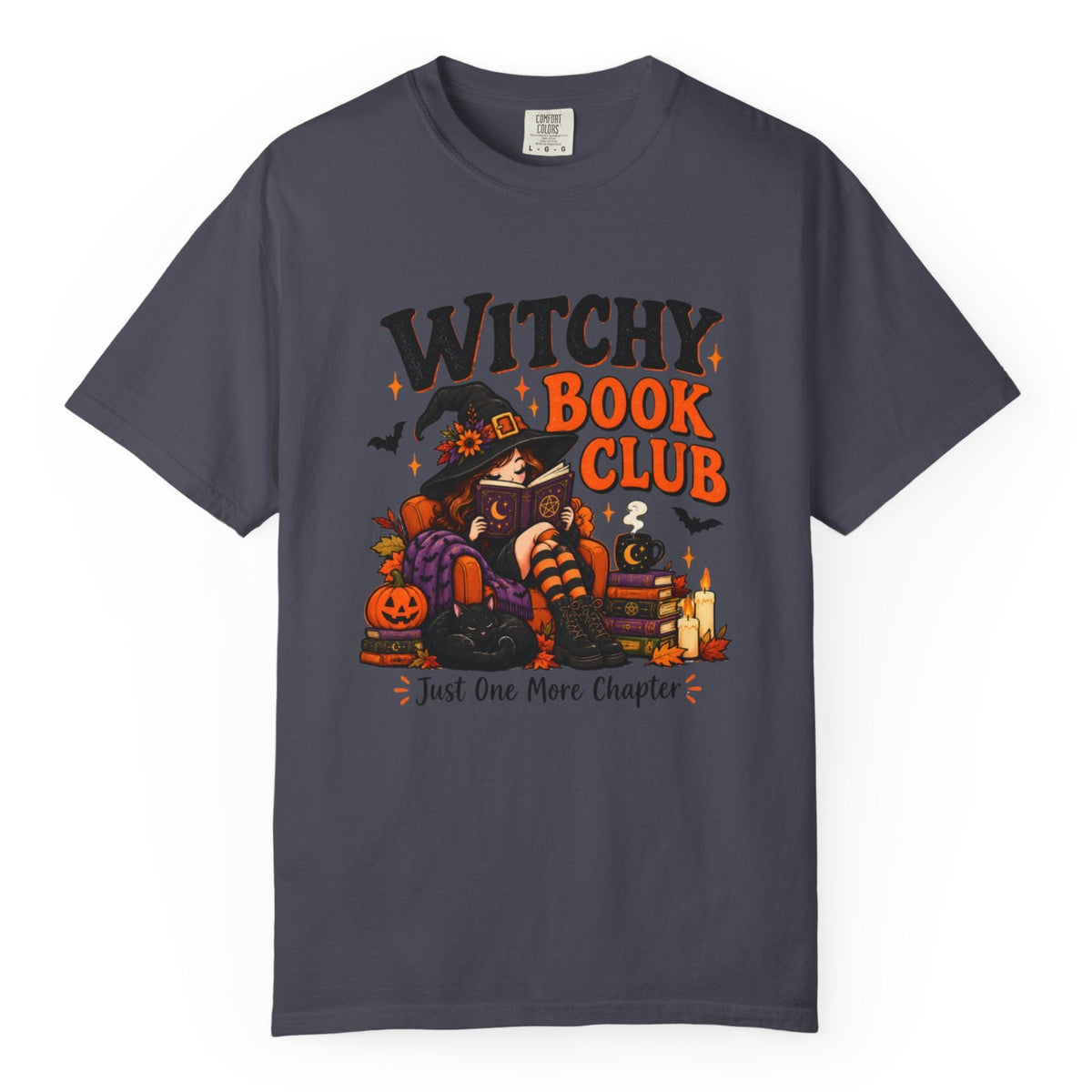 A navy blue crewneck t-shirt featuring a colorful graphic print on the front with the text 'WITCHY BOOK CLUB' and a Halloween-themed illustration of a witch, pumpkins, and candles.