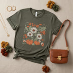 An olive green short-sleeve crewneck t-shirt featuring a square graphic print of white daisies, orange flowers, and orange pumpkins on a white background.