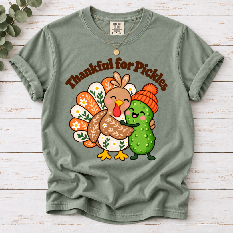 Bay Thankful for Pickles T-shirt featuring a cartoon turkey hugging a green pickle wearing an orange knit hat.”