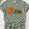Bay T-shirt featuring a cartoon pumpkin pie chasing a frightened pickle and turkey.