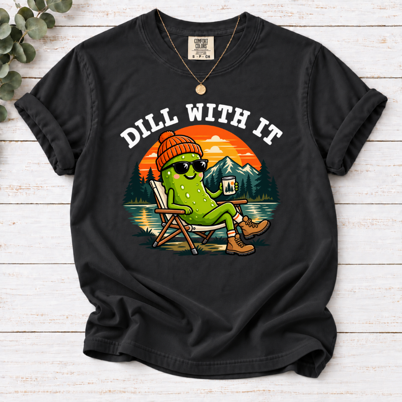 Black Dill With It T-shirt featuring a pickle in sunglasses relaxing in a camp chair beside a lake at sunset.