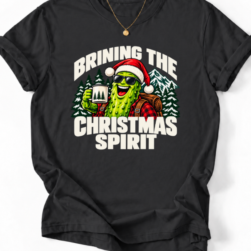 Black Brining the Christmas Spirit’ T-shirt featuring a pickle in a Santa hat and sunglasses holding a camping mug.