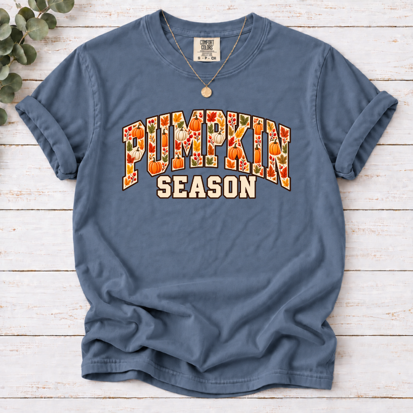 Blue Jean T-shirt with Pumpkin Season lettering filled with orange and white pumpkins and autumn leaves.