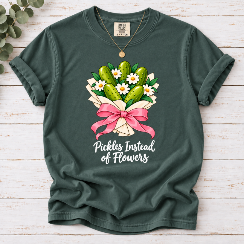 Blue Spruce T-shirt with a pickle and daisy bouquet, pink bow, and white ‘Pickles Instead of Flowers’ lettering