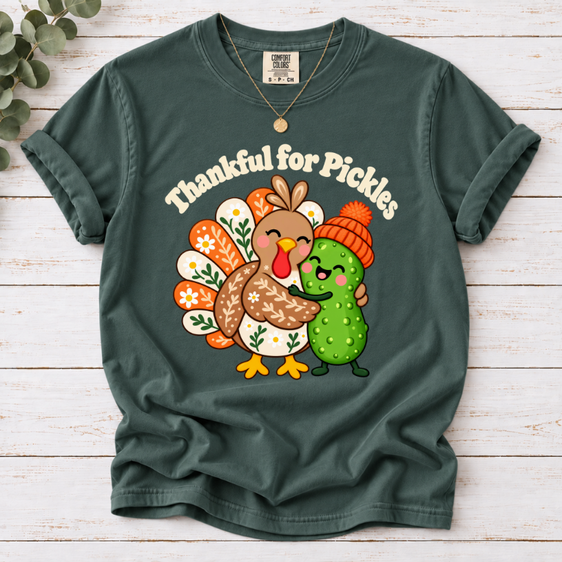 blue spruce Thankful for Pickles T-shirt featuring a cartoon turkey hugging a green pickle wearing an orange knit hat