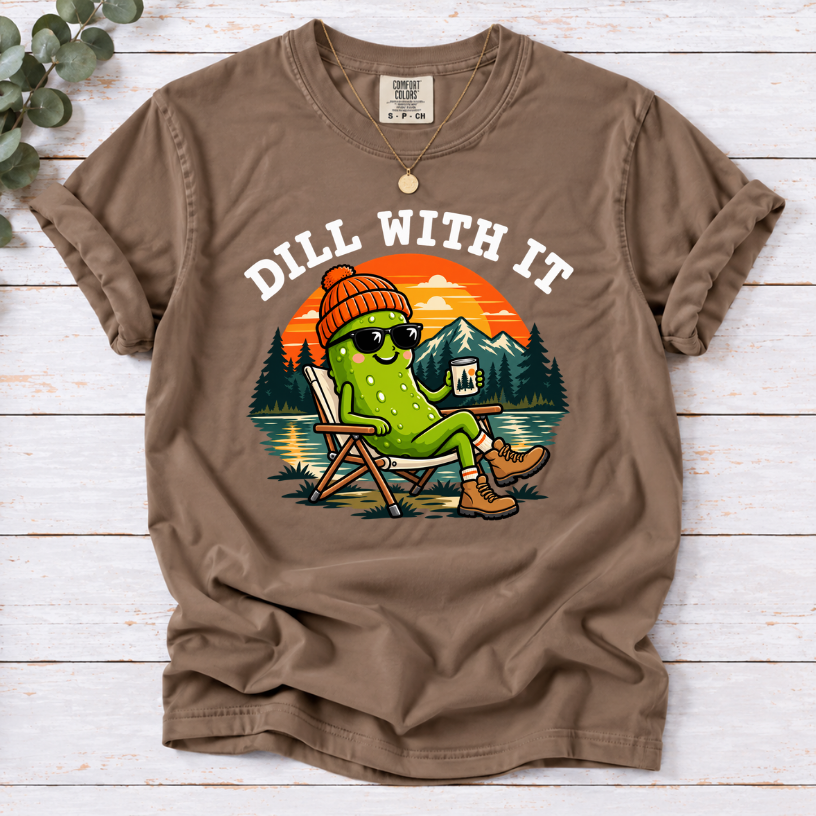 Espresso Dill With It T-shirt featuring a pickle in sunglasses relaxing in a camp chair beside a lake at sunset.