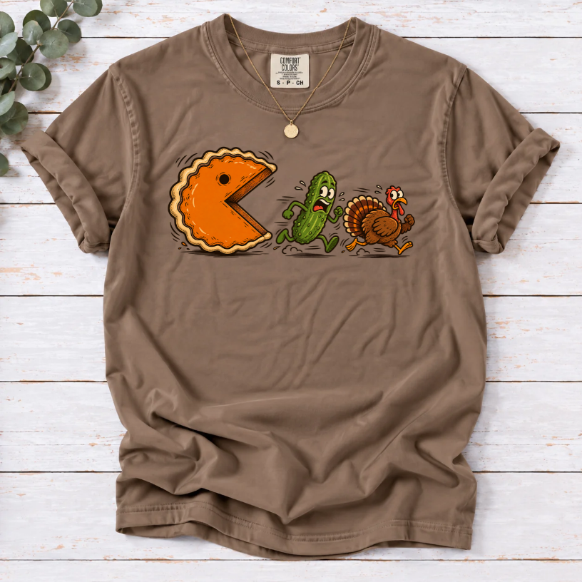 Espresso T-shirt featuring a cartoon pumpkin pie chasing a frightened pickle and turkey.