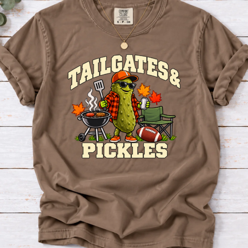 Espresso brown tailgates & Pickles’ T-shirt featuring a pickle grilling beside a folding chair, football, and fall leaves
