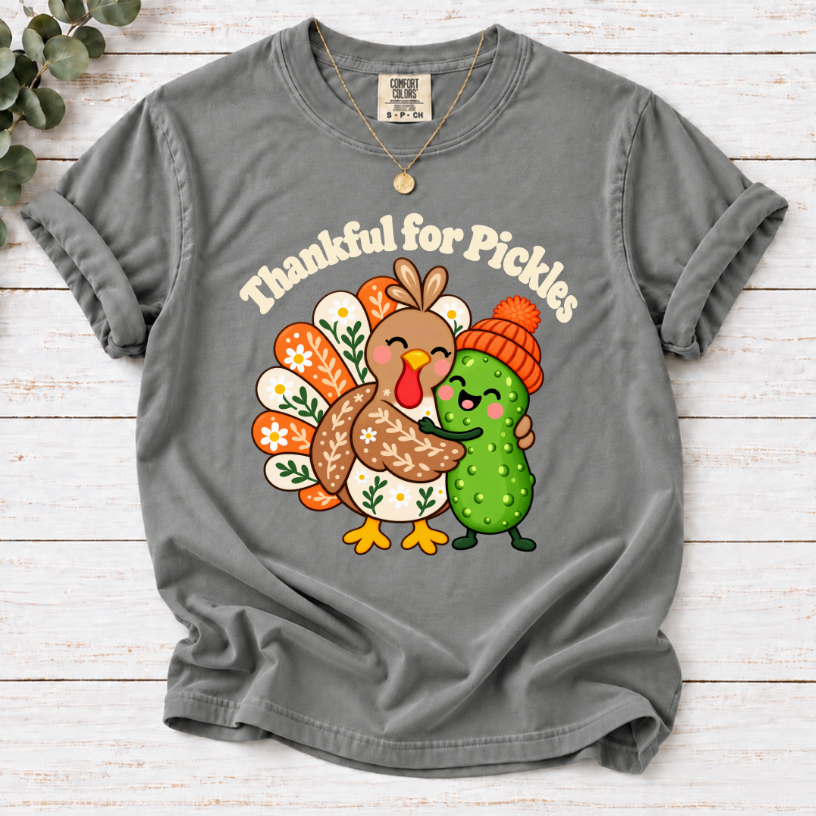grey Thankful for Pickles T-shirt featuring a cartoon turkey hugging a green pickle wearing an orange knit hat.