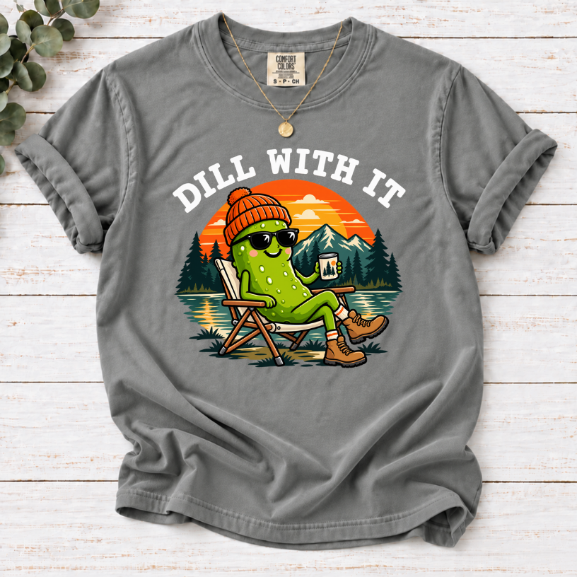 Grey Dill With It T-shirt featuring a pickle in sunglasses relaxing in a camp chair beside a lake at sunset.