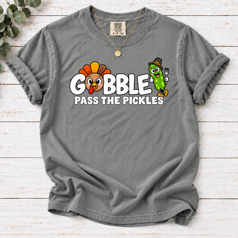 Grey T-shirt with ‘Gobble Pass the Pickles’ lettering, a cartoon turkey and a pilgrim pickle holding a fork.