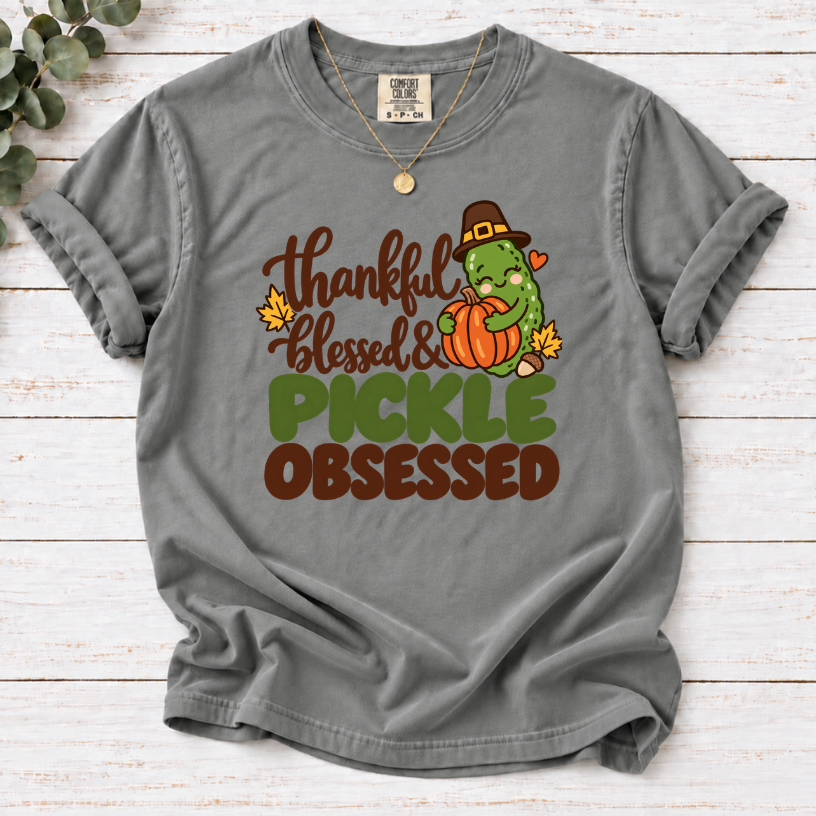 Grey T-shirt with ‘Thankful Blessed & Pickle Obsessed’ lettering and a pilgrim-hat pickle hugging a pumpkin
