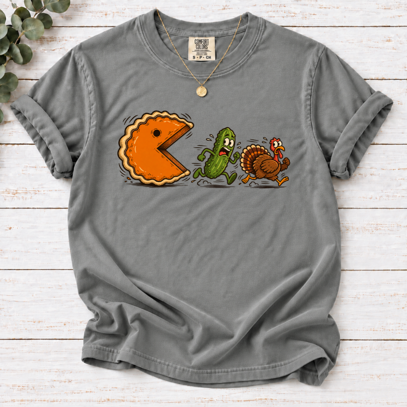 Grey T-shirt featuring a cartoon pumpkin pie chasing a frightened pickle and turkey.