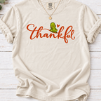 Ivory T-shirt with thankful script, a smiling green pickle, and a small orange heart.