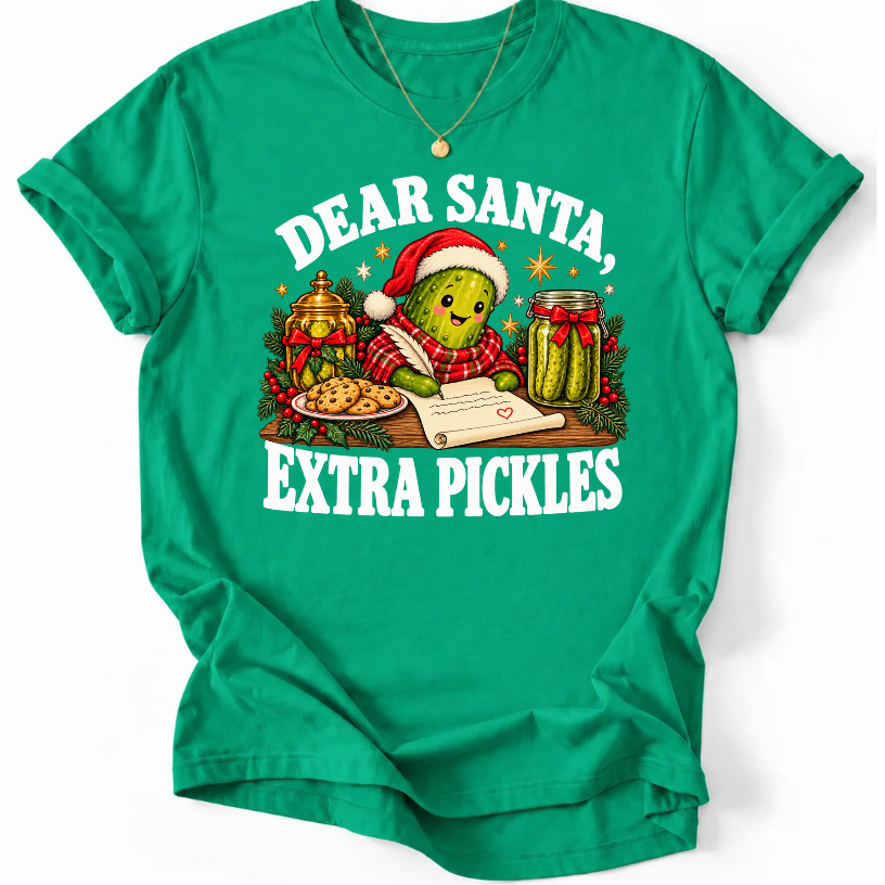 Kelly Green ‘Dear Santa, Extra Pickles’ T-shirt featuring a Santa-hat pickle writing a letter beside cookies and pickles.”