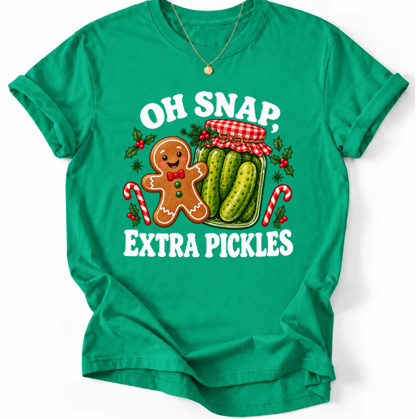 Kelly Green T-shirt with “Oh Snap, Extra Pickles” lettering, a smiling gingerbread character, and a pickle jar surrounded by candy canes and holly.