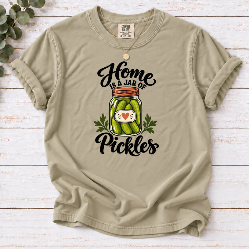 Khaki T-shirt with a heart-labeled pickle jar graphic and black ‘Home Is a Jar of Pickles’ lettering