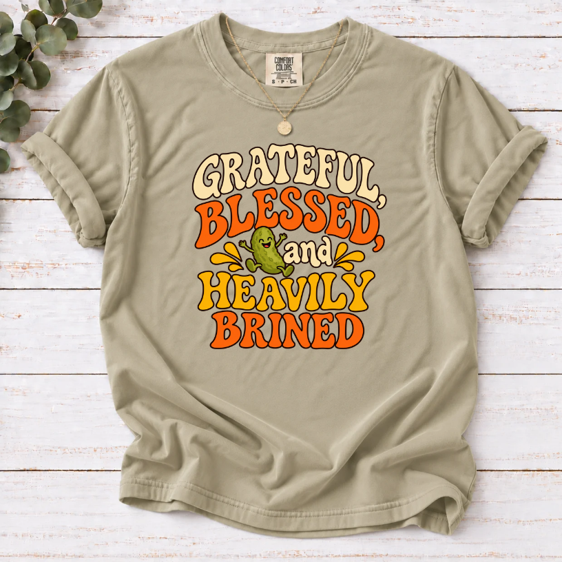 Khaki T-shirt with ‘Grateful, Blessed and Heavily Brined’ retro lettering and a smiling green pickle