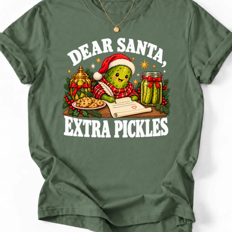 Military Green ‘Dear Santa, Extra Pickles’ T-shirt featuring a Santa-hat pickle writing a letter beside cookies and pickles.”