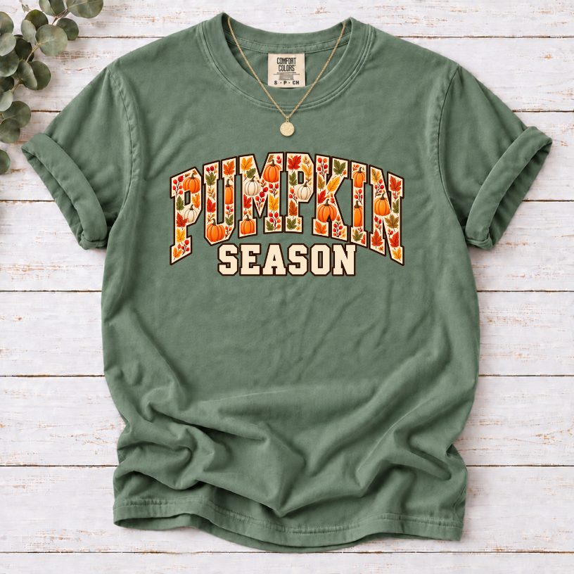 Moss T-shirt with Pumpkin Season lettering filled with orange and white pumpkins and autumn leaves.