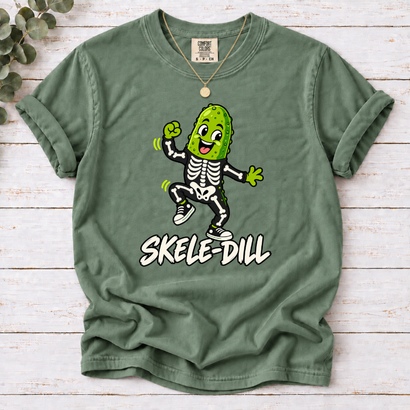 Moss green Skele-Dill T-shirt featuring a dancing pickle in a skeleton costume with SKELE-DILL lettering