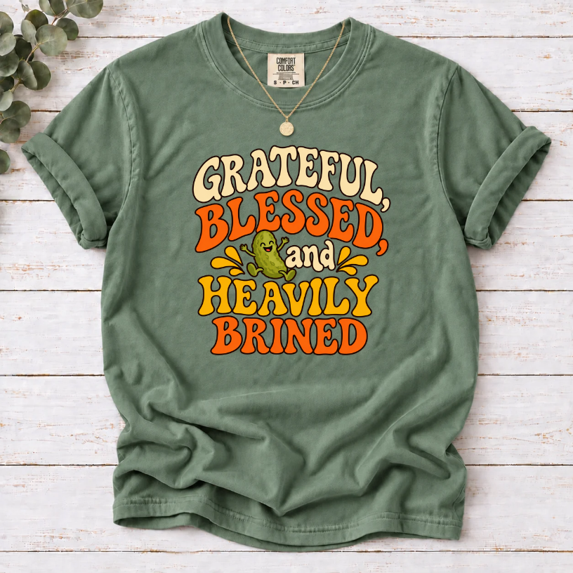 Moss T-shirt with ‘Grateful, Blessed and Heavily Brined’ retro lettering and a smiling green pickle