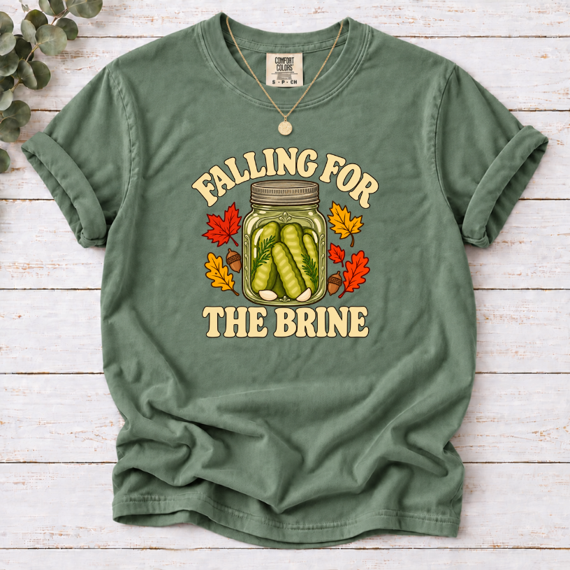 Moss T-shirt with “Falling for the Brine” lettering and a pickle jar surrounded by autumn leaves and acorns.