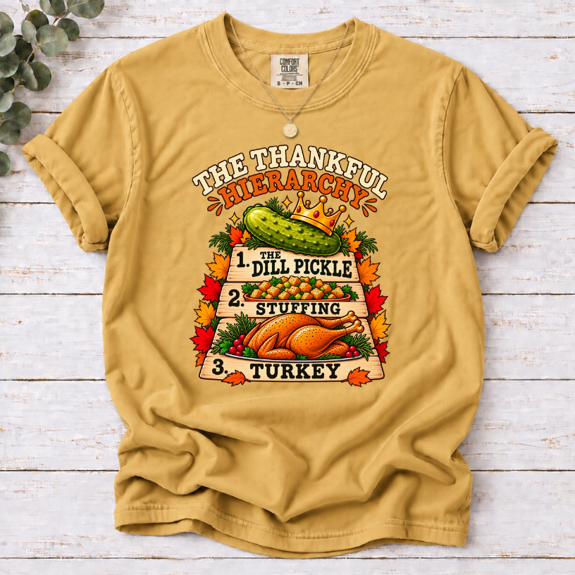 Mustard T-shirt with The Thankful Hierarchy design featuring a crowned dill pickle, stuffing, turkey, and fall leaves