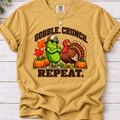 Mustard Gobble Crunch Repeat’ T-shirt featuring a sunglasses-wearing pickle beside a turkey, pumpkins, and fall leaves