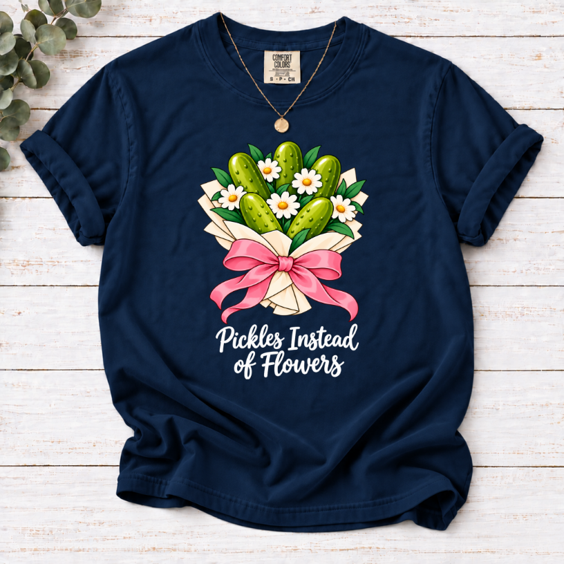 Navy T-shirt with a pickle and daisy bouquet, pink bow, and white ‘Pickles Instead of Flowers’ lettering