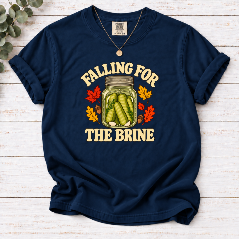 Navy T-shirt with “Falling for the Brine” lettering and a pickle jar surrounded by autumn leaves and acorns.