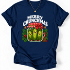 Navy T-shirt with “Merry Crunchmas” lettering above three smiling pickles in a jar decorated with a red bow and Christmas greenery.