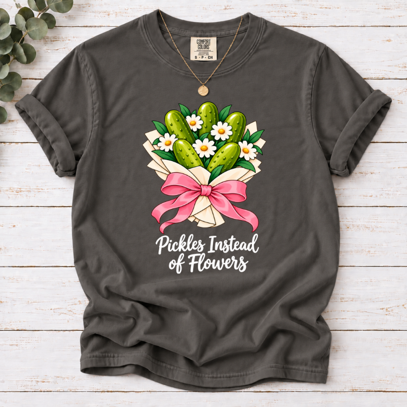 Pepper T-shirt with a pickle and daisy bouquet, pink bow, and white ‘Pickles Instead of Flowers’ lettering