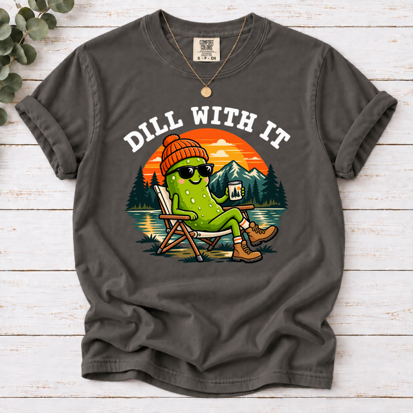 Pepper Dill With It T-shirt featuring a pickle in sunglasses relaxing in a camp chair beside a lake at sunset.