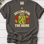 Pepper charcoal T-shirt with “Falling for the Brine” lettering and a pickle jar surrounded by autumn leaves and acorns.