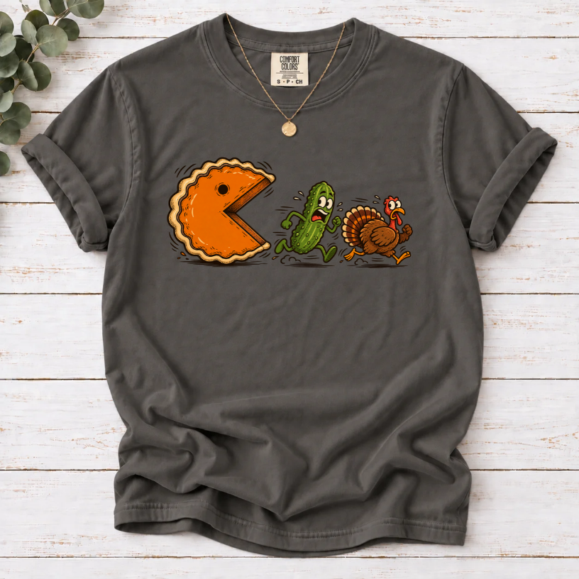 Pepper T-shirt featuring a cartoon pumpkin pie chasing a frightened pickle and turkey.