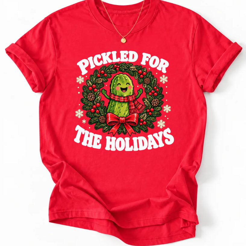 Red Pickled for the Holidays’ T-shirt with a smiling pickle in a red scarf inside a Christmas wreath.”