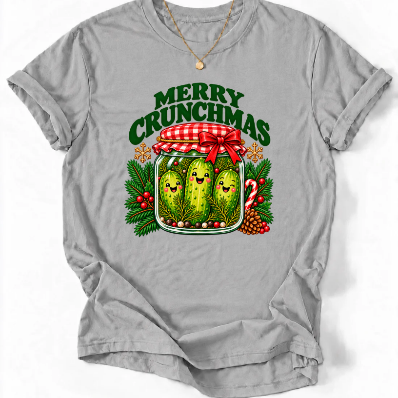 Sports Grey T-shirt with “Merry Crunchmas” lettering above three smiling pickles in a jar decorated with a red bow and Christmas greenery.