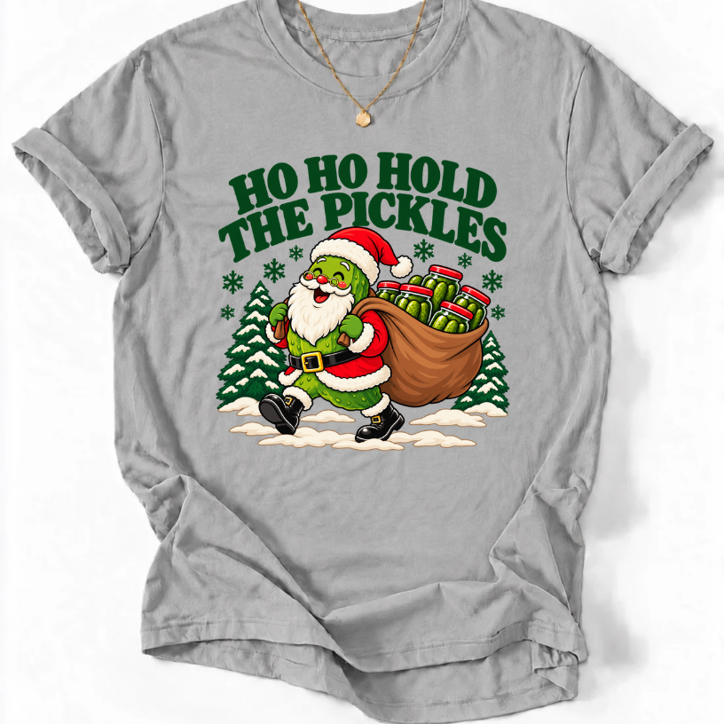 Sport Grey T-shirt with “Ho Ho Hold the Pickles” lettering and a pickle dressed as Santa carrying a sack of pickle jars beside snowy trees.